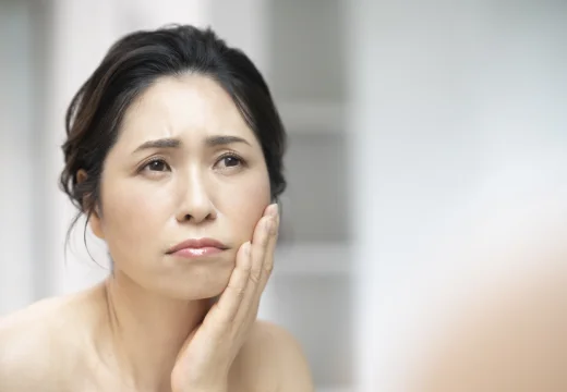 歯の痛みで頬を押さえる女性