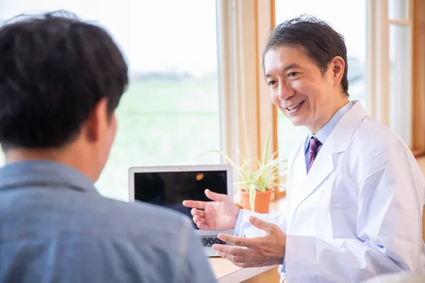 患者とカウンセリングする歯科医師