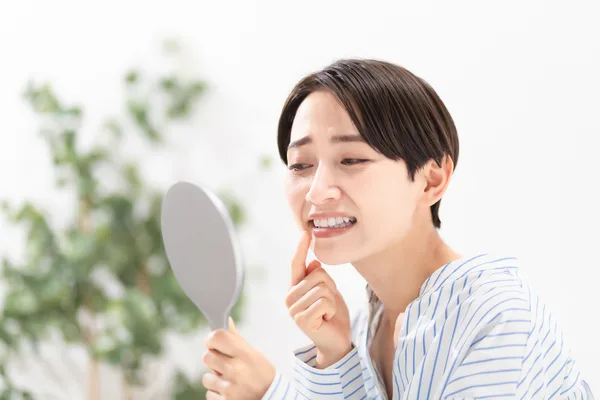 手鏡で仕上がりを確認する女性